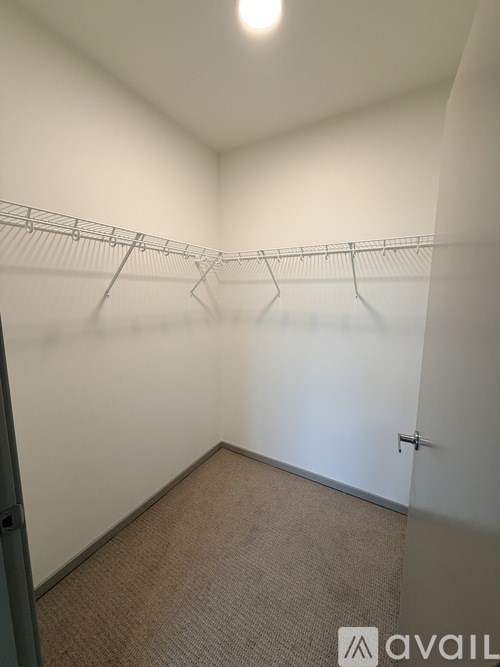 A room with a carpeted floor and a metal rack on the wall.