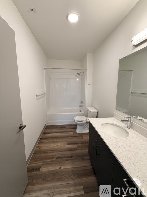 A bathroom with a toilet, sink, and mirror.