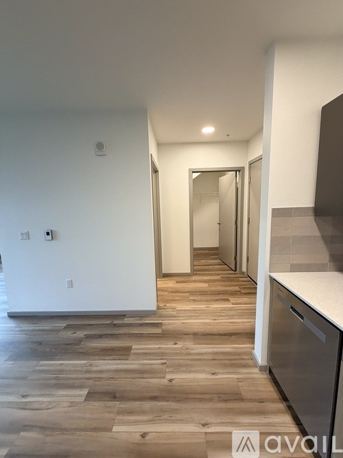 A hallway with a wooden floor and white walls.