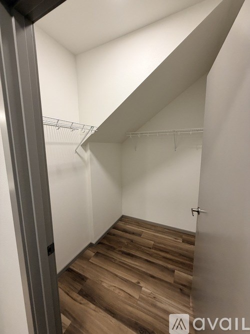 A hallway with a wooden floor and white walls.