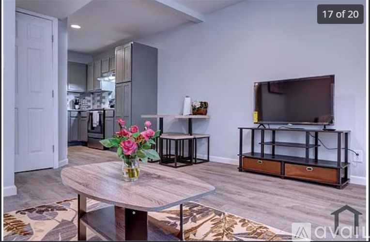 A living room with a wooden table and a television on a stand.