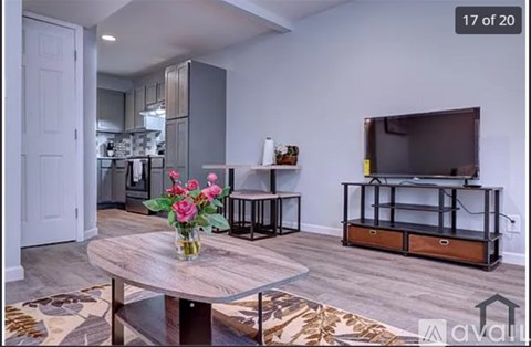 A living room with a wooden table and a television on a stand.