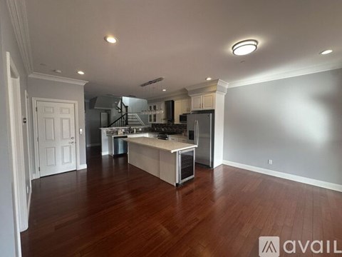 A kitchen with a refrigerator, sink, and cabinets is available for rent.