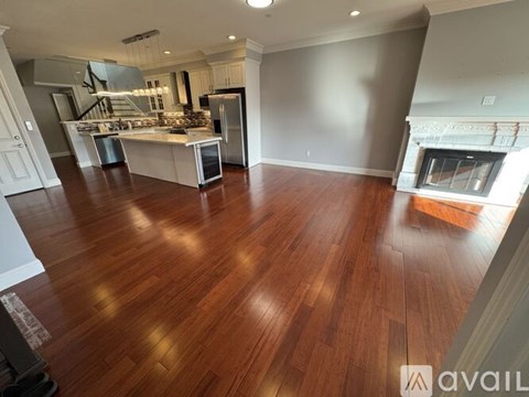 A spacious kitchen with wood flooring and a fireplace.