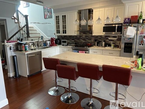 A kitchen with a bar stool in front of a counter.