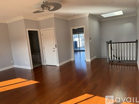 A room with wooden floors and a ceiling fan.