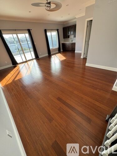 A room with wooden flooring and a ceiling fan.