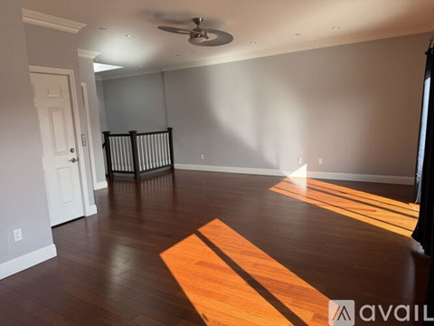 A room with wooden floors and a ceiling fan.