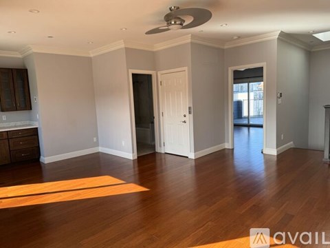 A room with wooden floors and a ceiling fan.