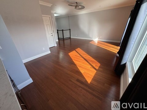 A room with wooden flooring and a ceiling fan.