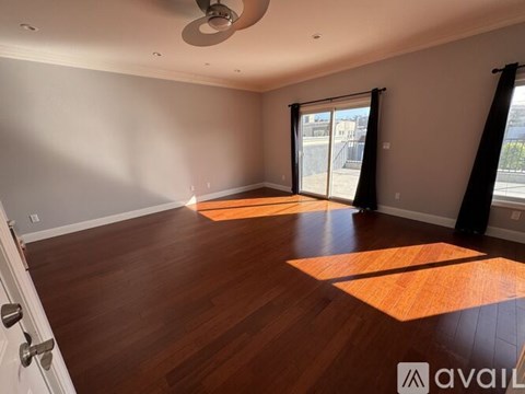 A room with wooden flooring and a ceiling fan.