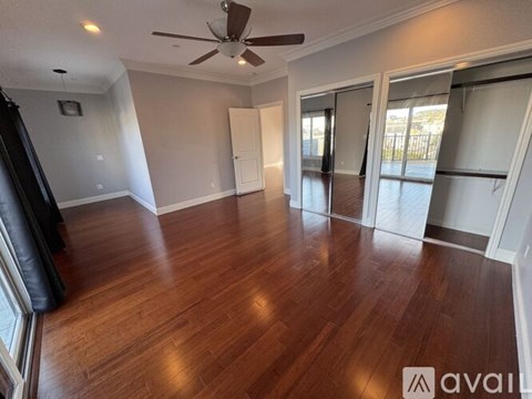 A room with wooden floors and a ceiling fan.