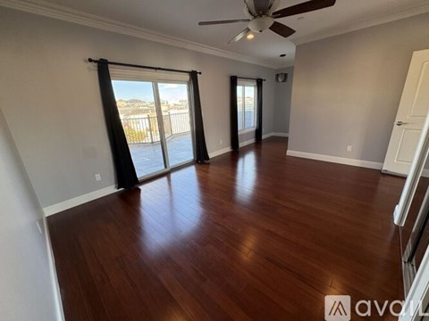 A room with wooden floors and a ceiling fan.