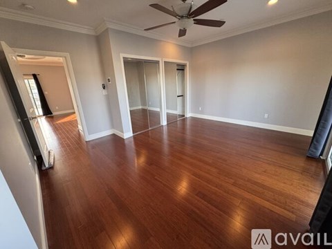 A room with wooden flooring and a ceiling fan.