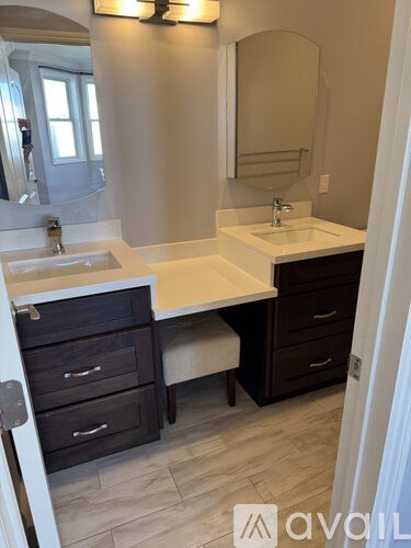 A bathroom with a sink, mirror, and drawers.