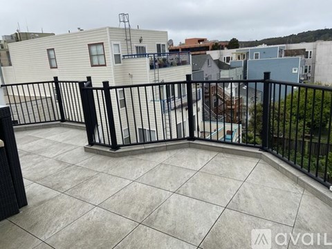A balcony with a black railing and tiled floor.