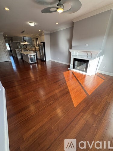 A room with wooden floors and a fireplace is available for rent.