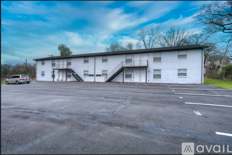 A large white building with a parking lot in front.