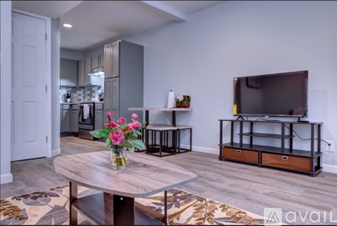 A living room with a wooden coffee table and a television on a wooden stand.