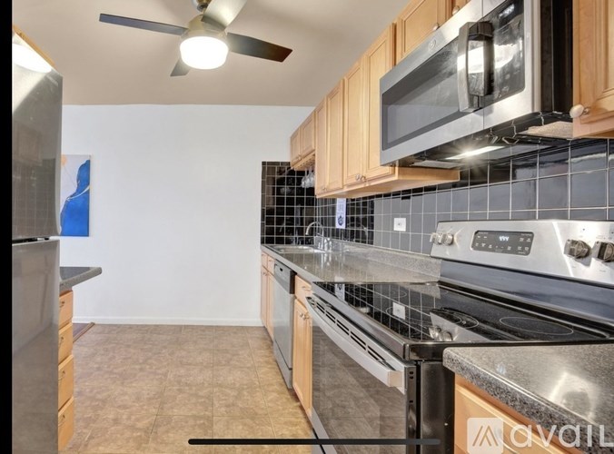 A kitchen with a black fridge, black stove, and a black microwave.