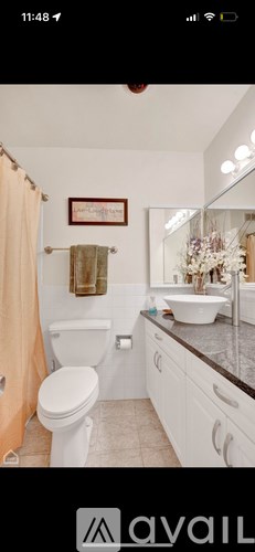 A bathroom with a toilet, sink, and mirror.