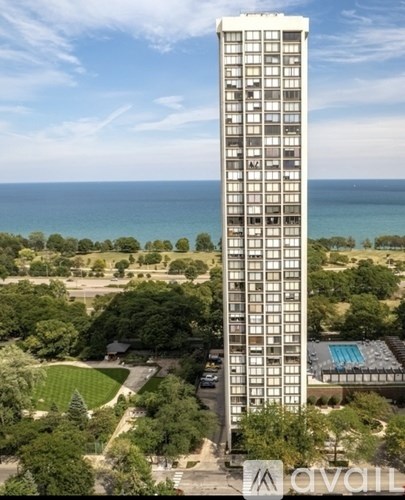 A tall building with a pool in front of it.