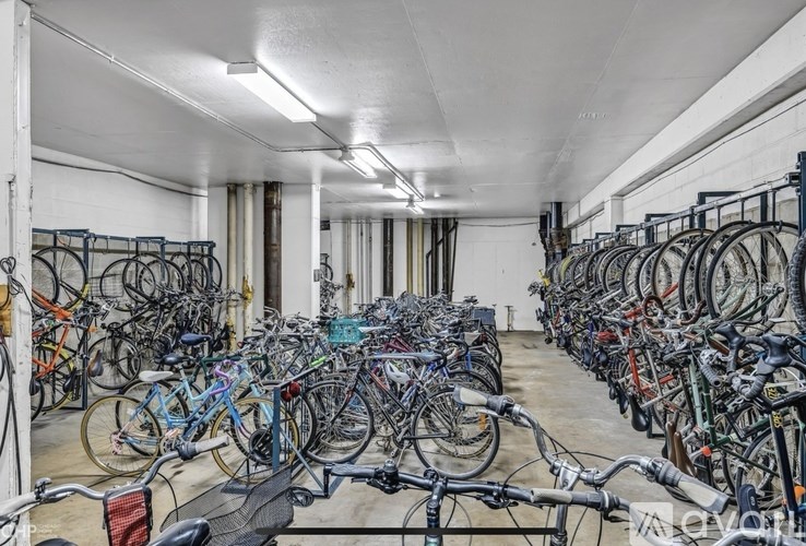 A large room full of bicycles parked in rows.
