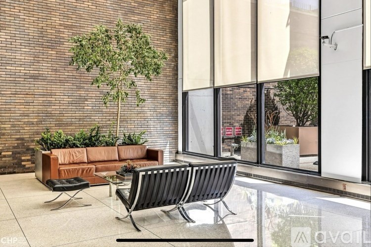 A patio with a bench, a table and a tree.