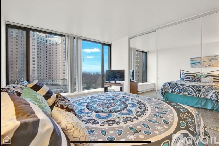 A bedroom with a large bed and a view of the city.