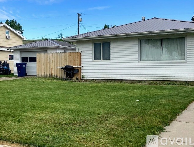 A house with a grey roof and a white fence.