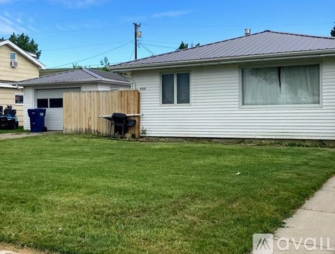 A house with a grey roof and a white fence.