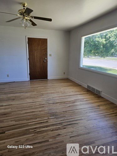 A room with a wooden floor and a ceiling fan.