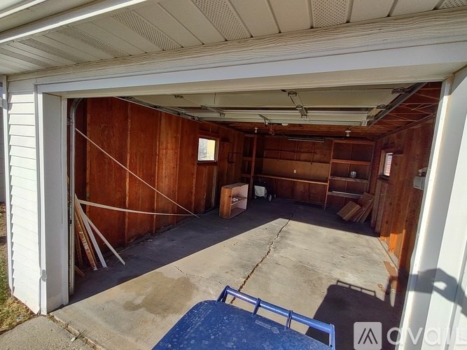 A garage with a concrete floor and wooden walls.