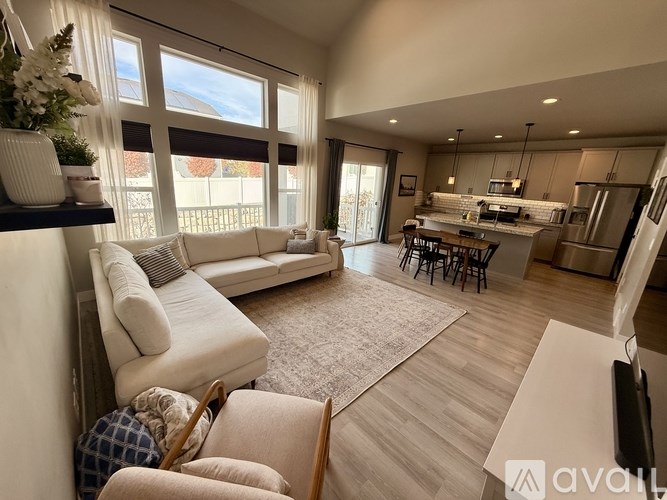 A living room with a white sofa and a dining table.