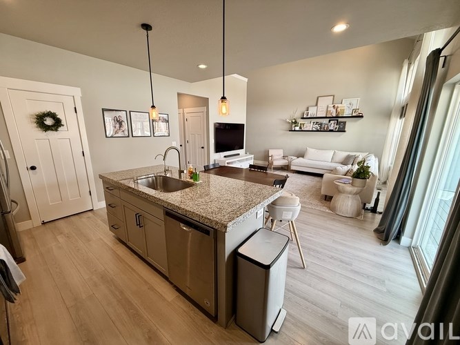 A modern kitchen with a granite countertop and stainless steel appliances.