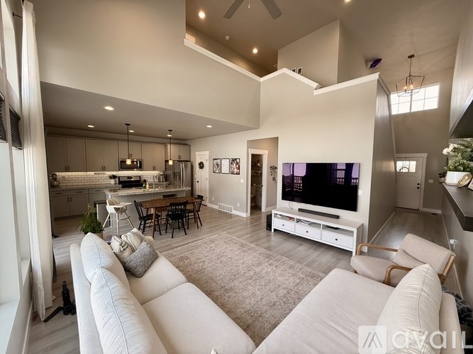 A modern living room with a large white sofa and a television.
