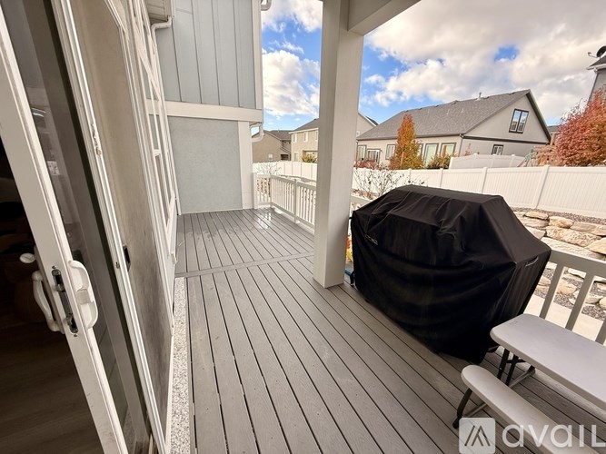 A balcony with a black cover and white furniture.