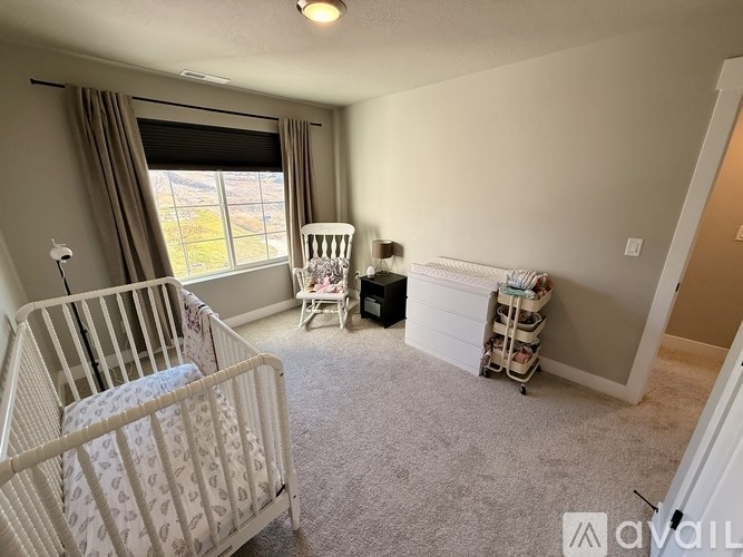A baby room with a crib, rocking chair, and a changing table.