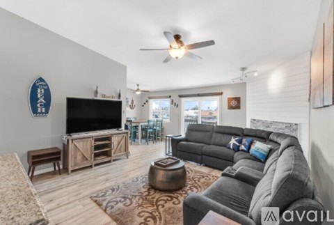 A living room with a grey couch and a wooden entertainment center.