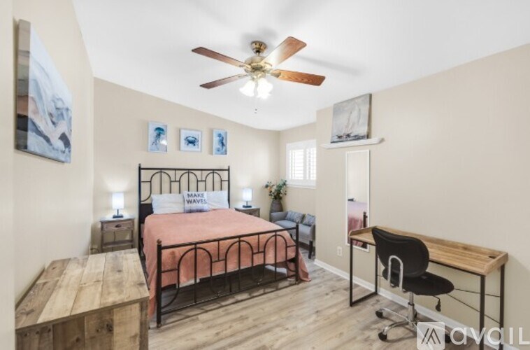 A bedroom with a bed, desk, and chair.