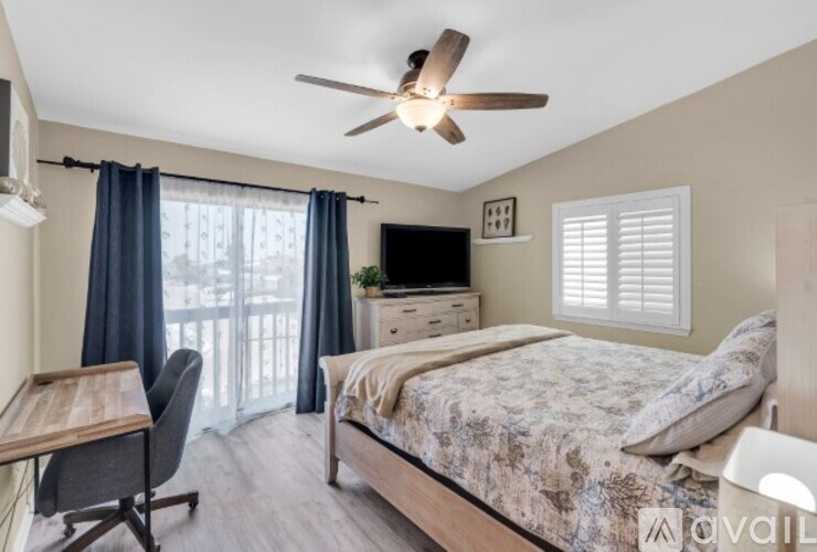 A bedroom with a bed, desk, and chair.