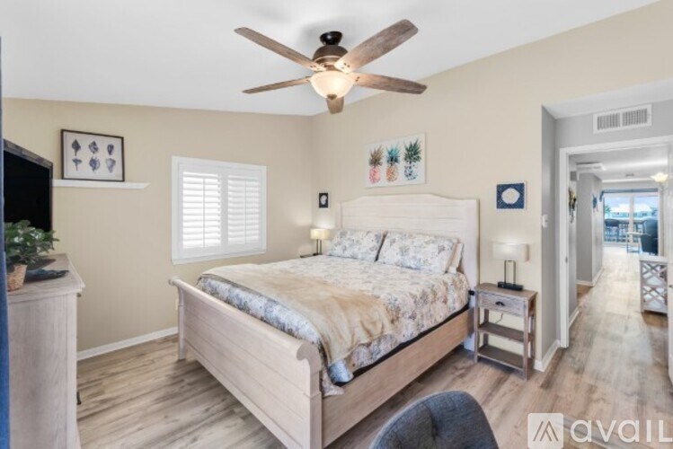 A bedroom with a large bed and a ceiling fan.