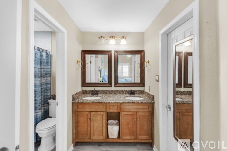 A bathroom with a granite countertop and wooden cabinets.