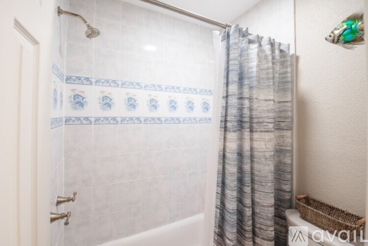A bathroom with a shower curtain and a white bathtub.