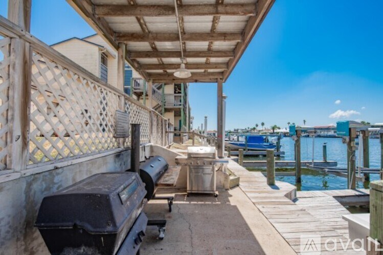 A wooden pier with a grill and a bench.