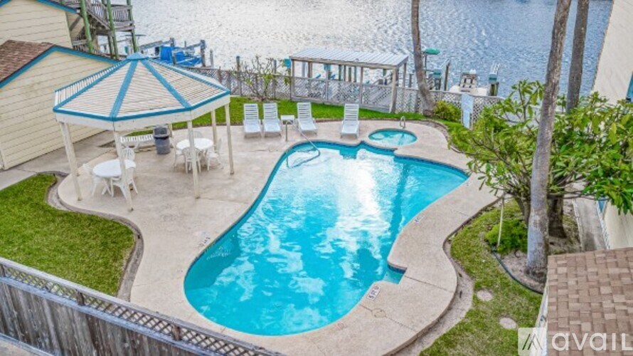 A small pool with a blue umbrella and chairs.