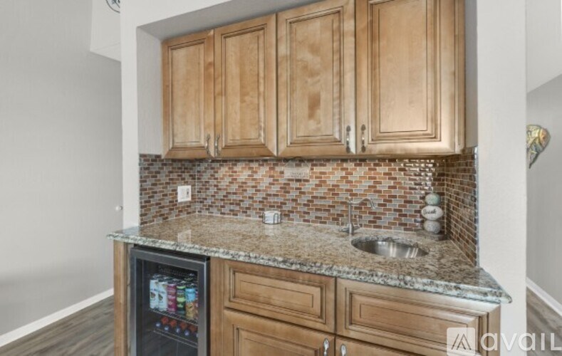 A kitchen with wooden cabinets and a granite countertop.