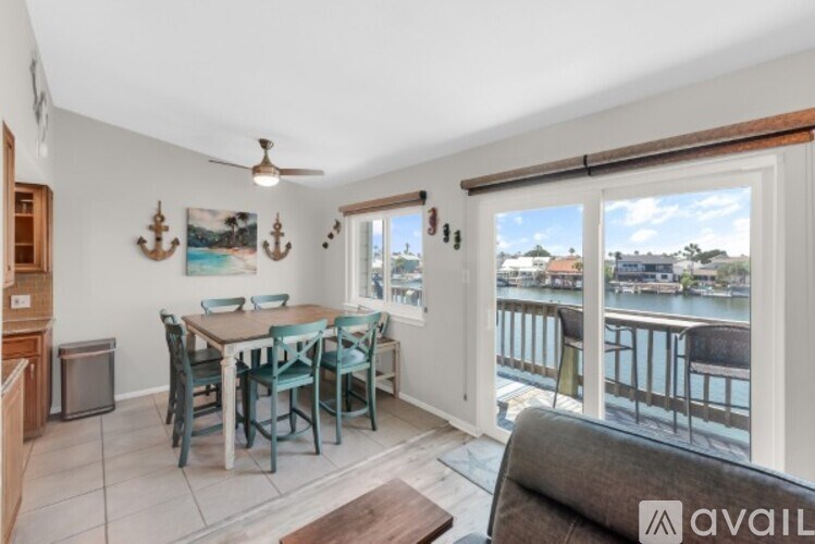 A dining area with a table set for six and a view of the water.