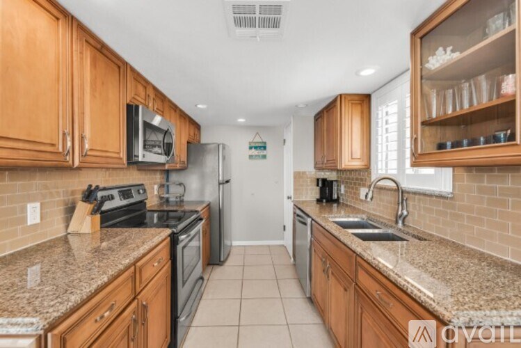 A kitchen with wooden cabinets and granite countertops.