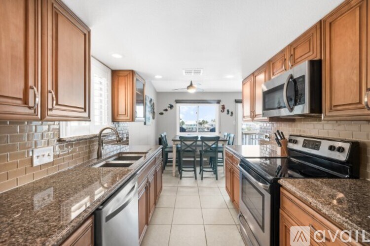 A kitchen with brown cabinets and a granite countertop.